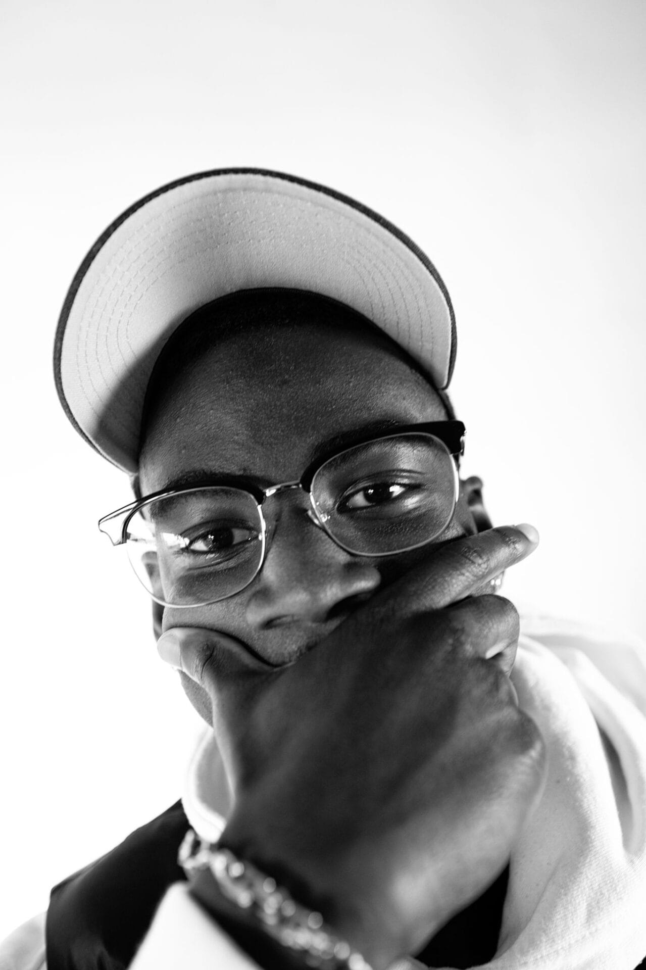 Schwarz-Weiß Portrait einer lässigen, jungen Person mit Brille und Cap.