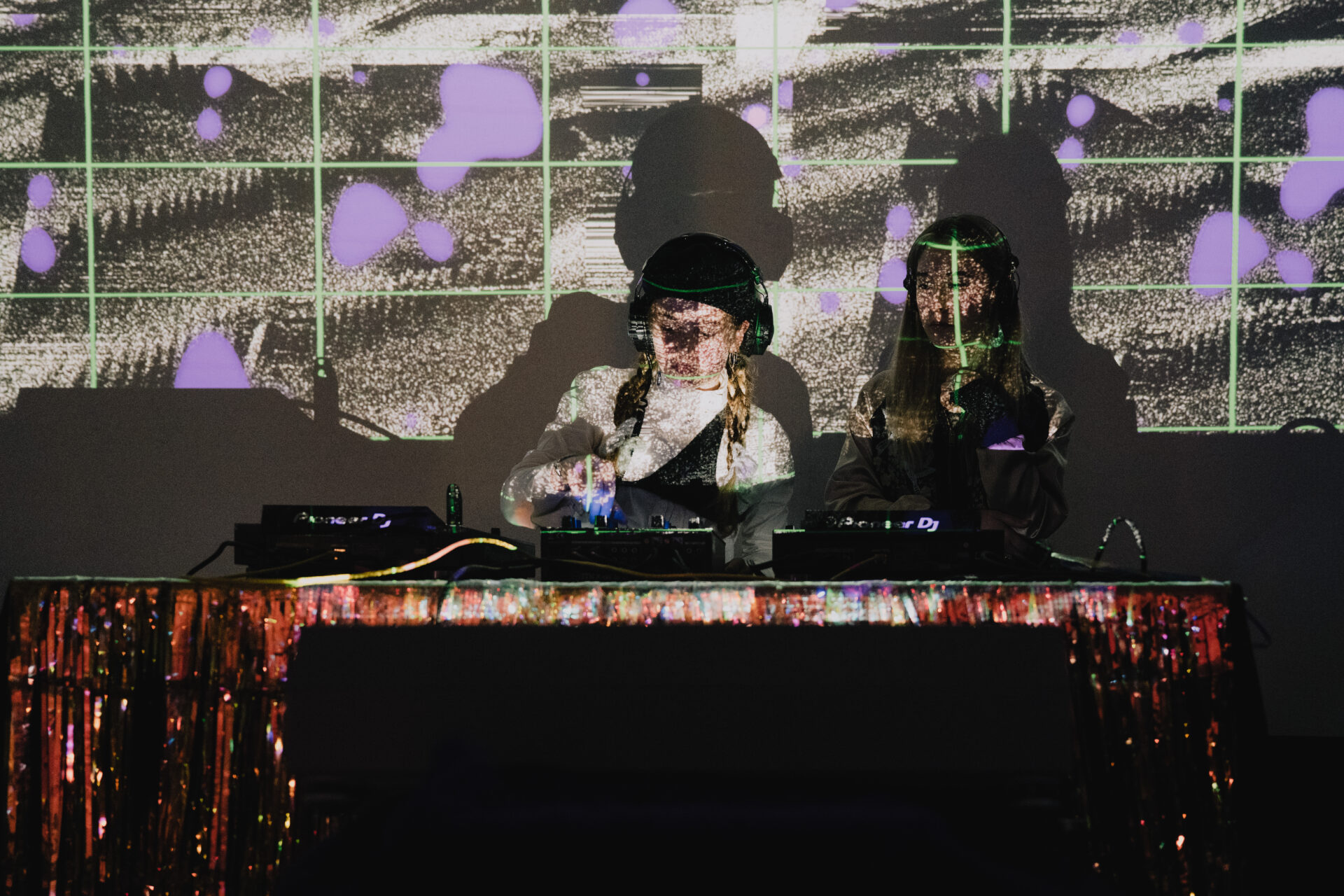 Zwei Personen stehen hinter einem DJ-Pult.