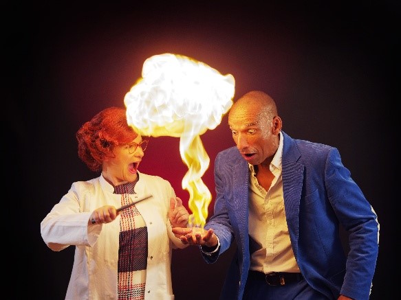 Ein Mann und eine Frau bei einem Experiment mit Feuer in der hand des Mannes