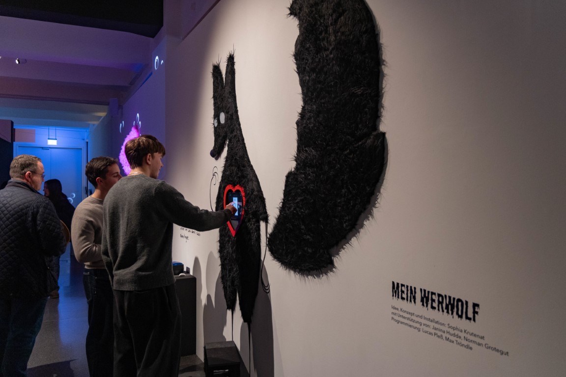 Drei Menschen stehen am Kunstwerk 