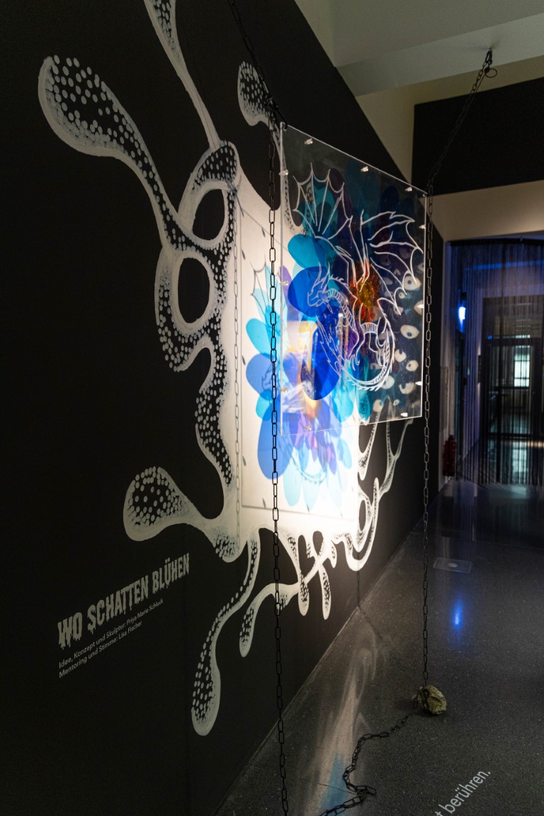 Vor einer schwarzen Wand ist das Kunstwerk 