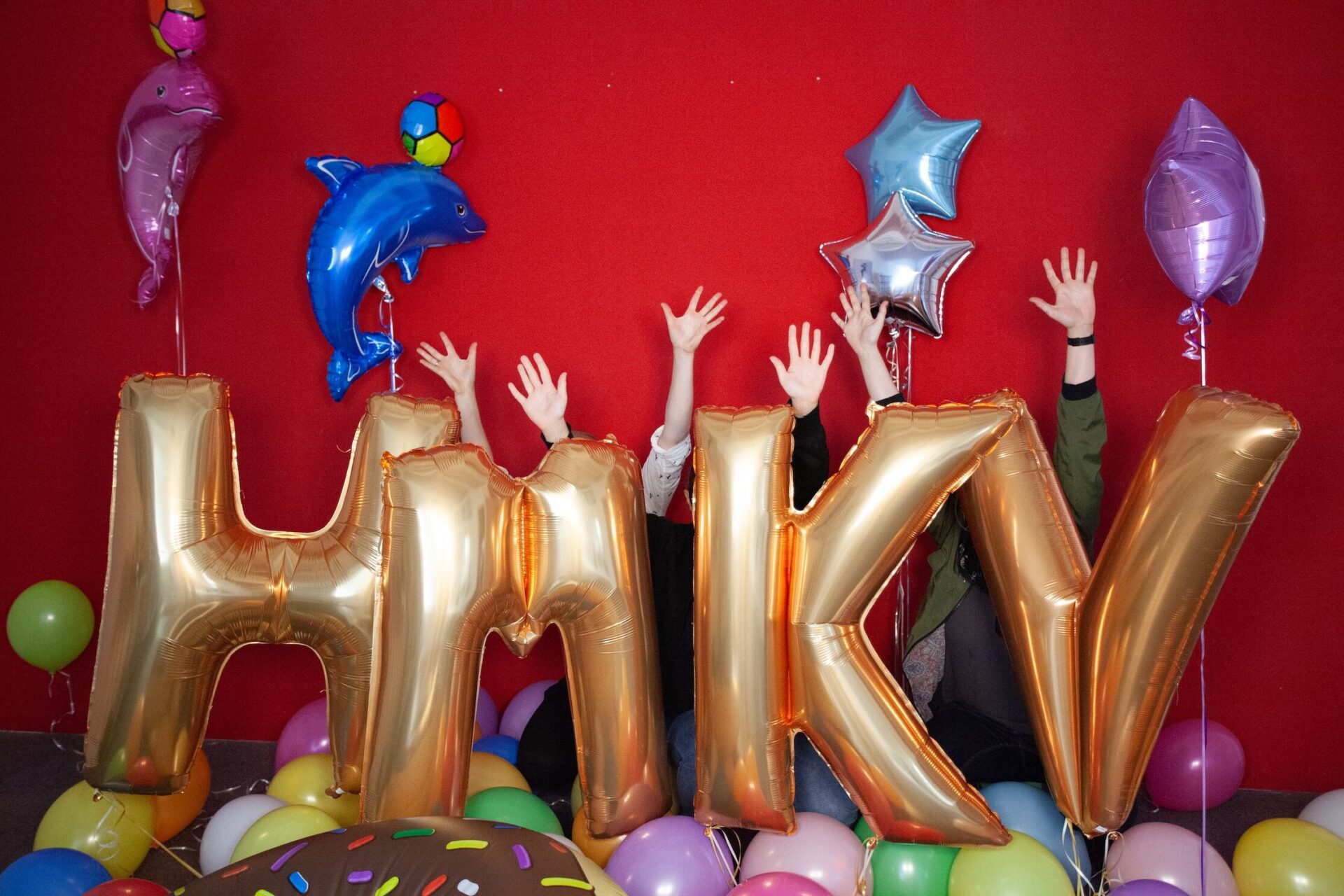 Aufgeblasene Buchstaben in Gold, HMKV. Davor Luftballons.