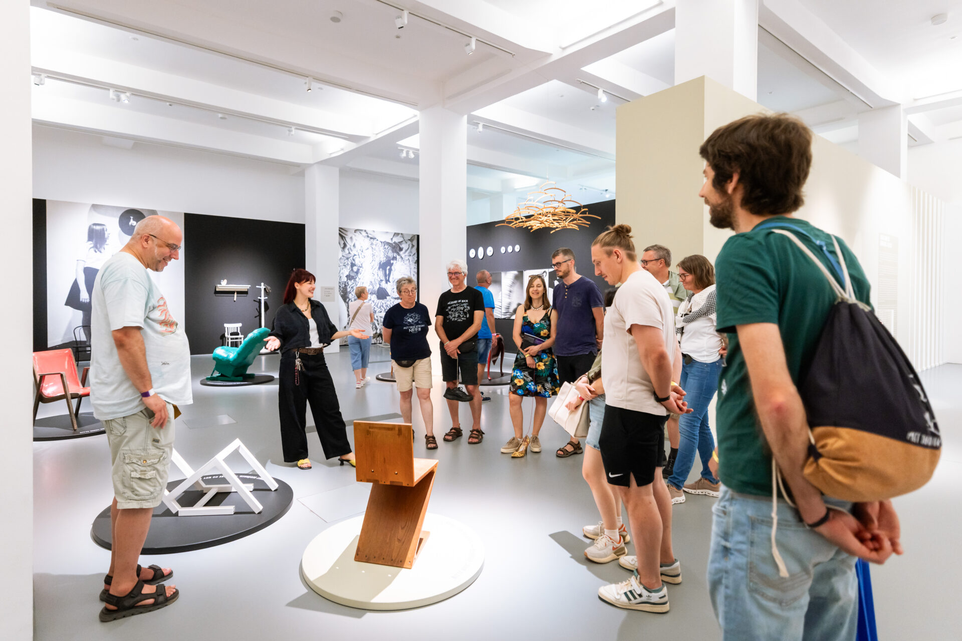 Eine Gruppe von Museumsbesucher*innen steht in einem hellen Ausstellungsraum.