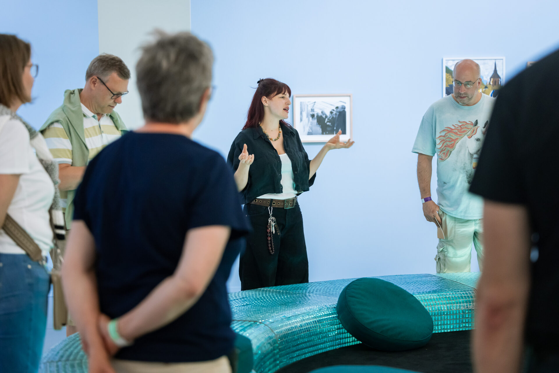 Eine Gruppe von Museumsbesucher*innen steht in einem hellen Ausstellungsraum.