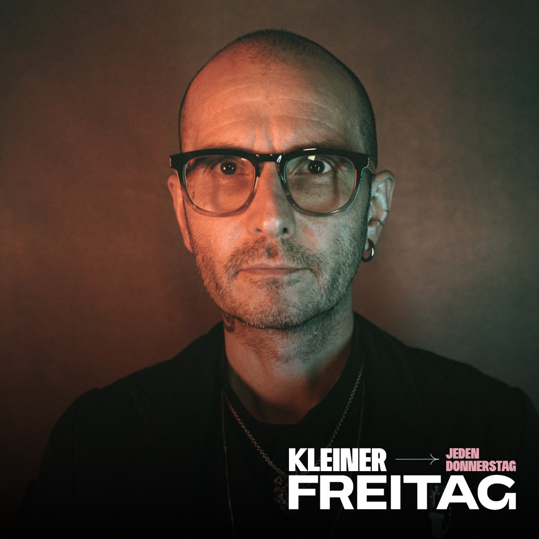 Porträt einer Person mit Brille und Ohrring vor braunem Hintergrund