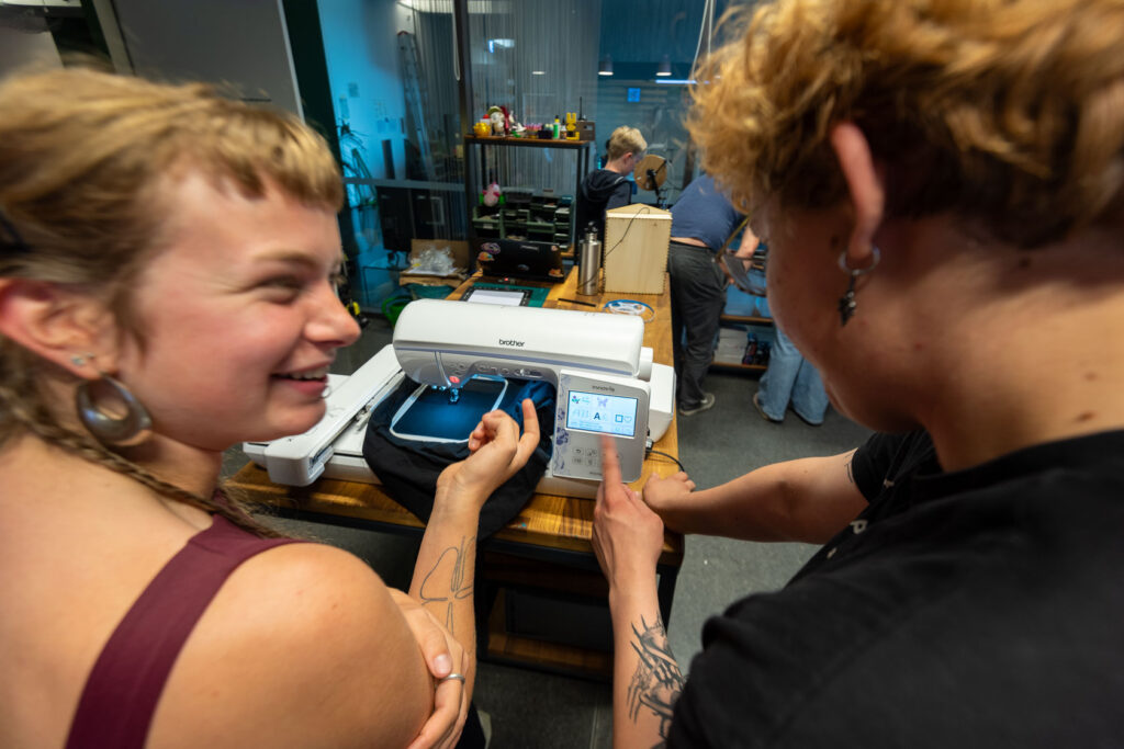 Zwei Personen vor einer Nähmaschine im Makerspace der uzwei