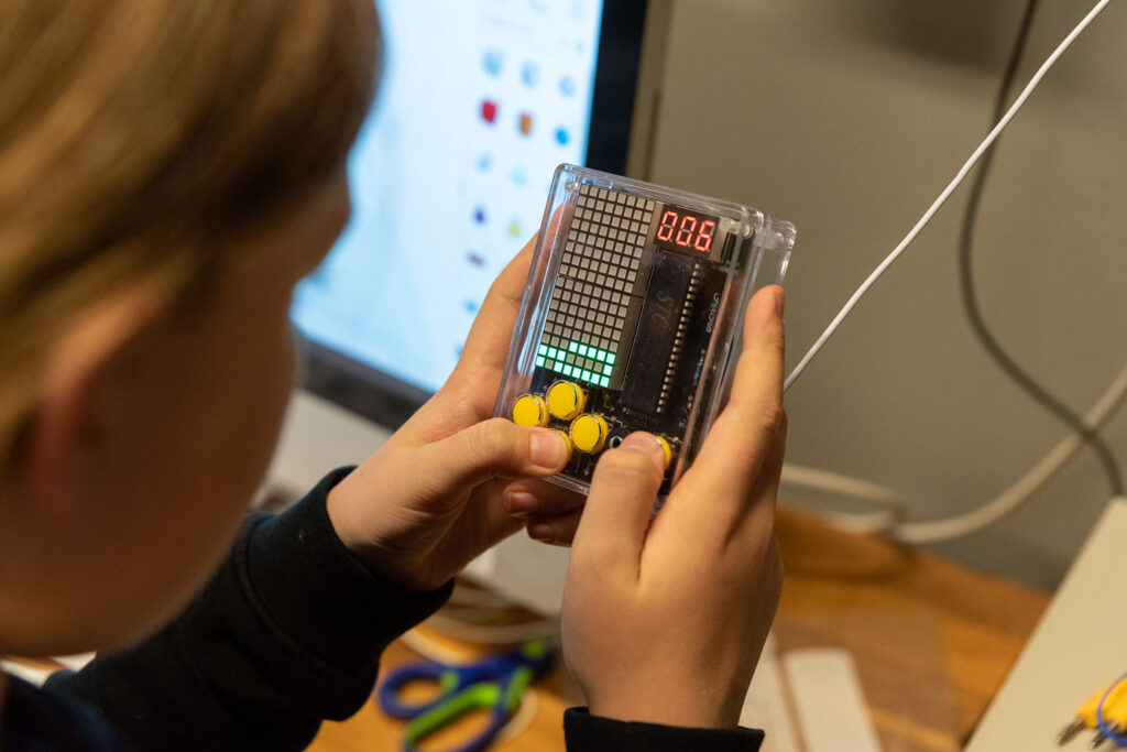 Kind hält ein selbstgebautes Computerspiel