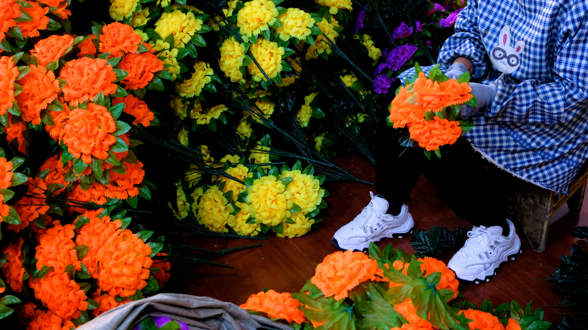 Blumenpflückerin mit Turnschuhen im Blumenmeer