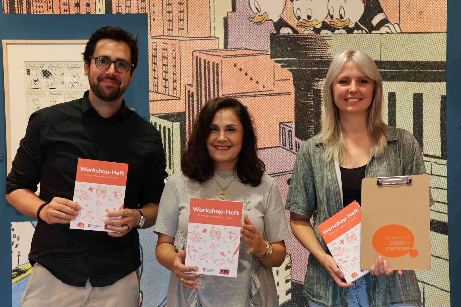 Matthias Flüß (Pädagogischer Mitarbeiter MIA-DO-Kommunales Integrationszentrum) Reyhan Güntürk (Leitung MIA-DO-Kommunales Integrationszentrum) und Sophia Gloe, Leitung schauraum: comic + cartoon) präsentieren das neue Workshop-Heft