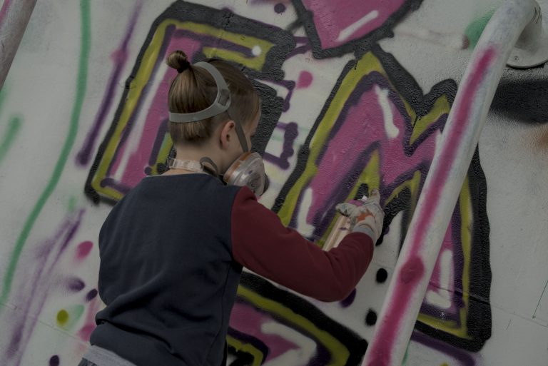 Kind sprüht ein Graffiti