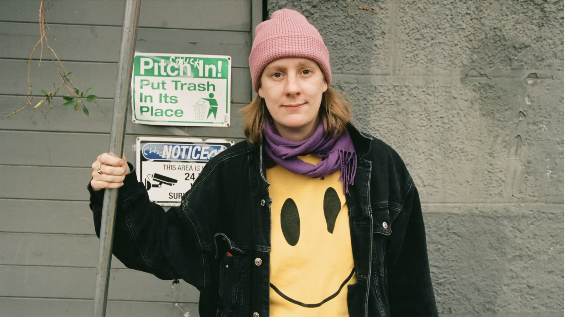 Die Künstlerin Anna Haifisch steht an einem Straßenschild.